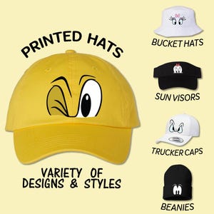 May include: A variety of printed hats with different designs and styles. The hats include bucket hats, sun visors, trucker caps, and beanies. The hats feature cartoon eyes and a winking face.
