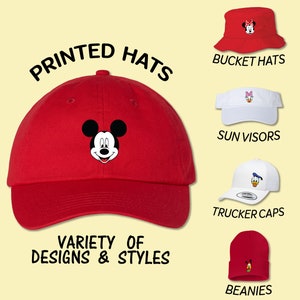 May include: A variety of printed hats featuring Disney characters. The hats include bucket hats, sun visors, trucker caps, and beanies. The text "PRINTED HATS" and "VARIETY OF DESIGNS & STYLES" is displayed on the image.