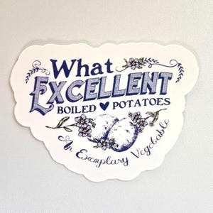 May include: A white sticker with a scalloped edge featuring the text "What Excellent Boiled Potatoes" in blue script. Two illustrated potatoes are adorned with blue flowers, and the phrase "An Exemplary Vegetable" is written below.