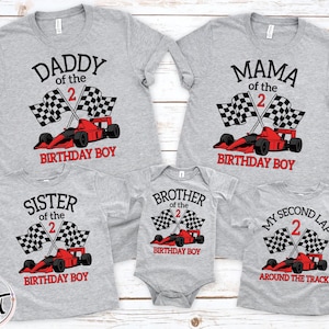 May include: A collection of five grey t-shirts and one grey baby bodysuit featuring a red race car, two checkered flags, and the number 2 in red. The shirts display text including Daddy of the 2 Birthday Boy, Mama of the 2 Birthday Boy, and My Second Lap.