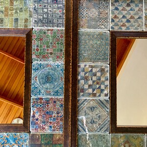 May include: A decorative mirror with a wooden frame and a mosaic of colorful tiles. The tiles are arranged in a grid pattern and feature various geometric designs. The mirror is reflecting a wooden ceiling.