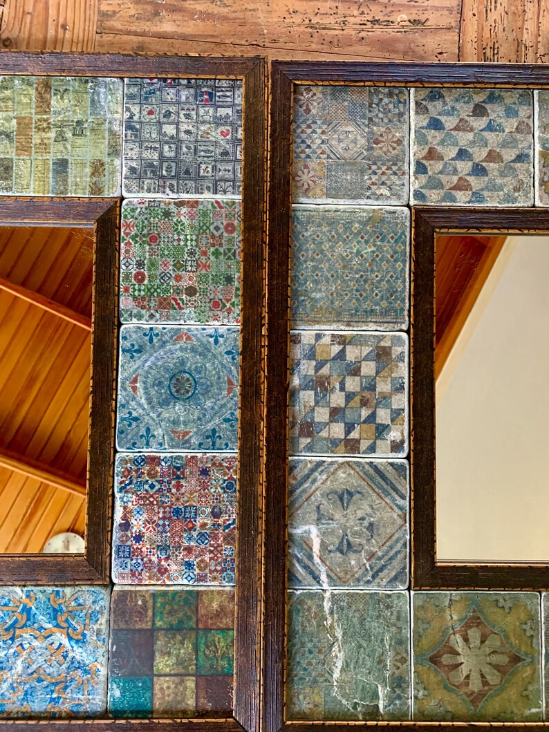 May include: A decorative mirror with a wooden frame and a mosaic of colorful tiles. The tiles are arranged in a grid pattern and feature various geometric designs. The mirror is reflecting a wooden ceiling.