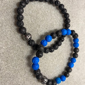 May include: Two beaded bracelets, one black and one with black and blue beads.