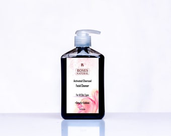 May include: A black, square bottle of Roses Natural Activated Charcoal Facial Cleanser with a white pump. The label includes the product name, brand, and the words "For All Skin Types". The label also says "Detoxify • Exfoliate". The bottle contains 266 ml of product.