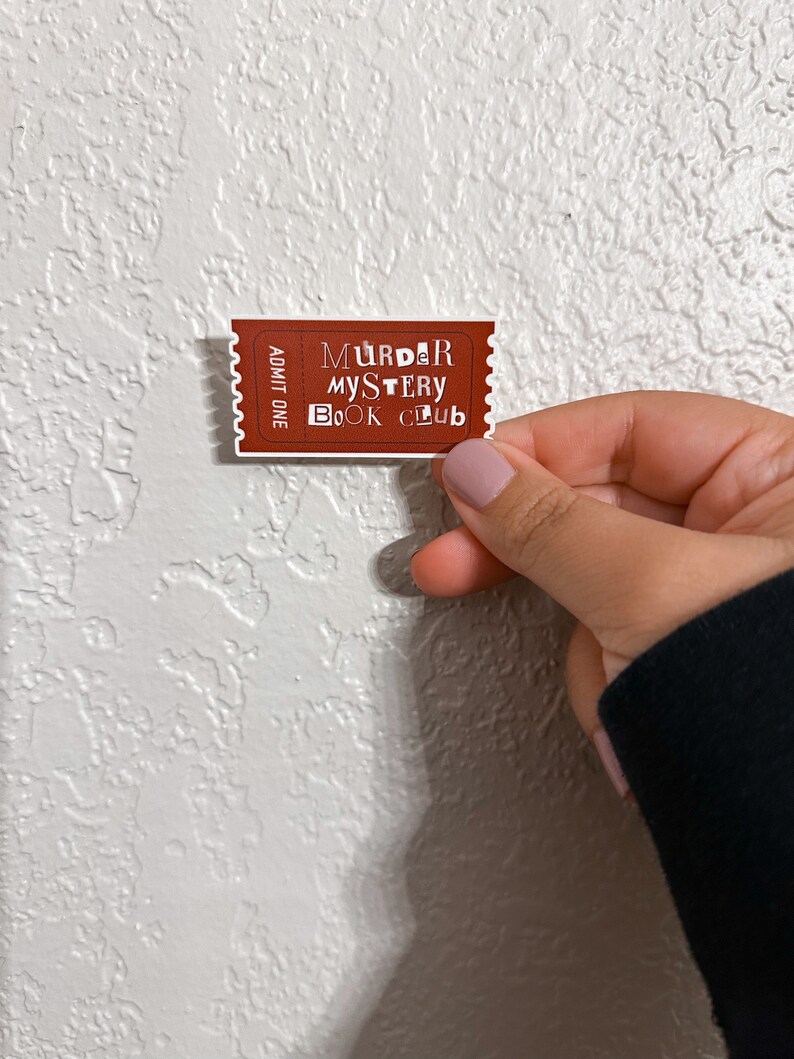 May include: A brown ticket with white text that reads "Murder Mystery Book Club" and "Admit One".