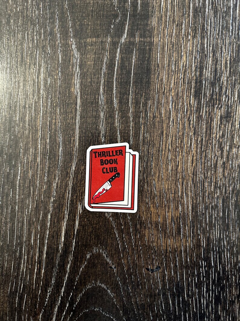 May include: Red book sticker with the text "Thriller Book Club" and a bloody knife sticking out of it.