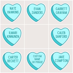 May include: Nine blue heart-shaped stickers with white outlines. Each sticker has a different name written on it. The names are Nate Hawkins, Evan Zanders, Ilmari Kinnunen, Garrett Graham, Caleb Sanford, Carter Beckett, Jake Compton, and Custom Name or Phrase.