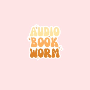 May include: A sticker with the text "AUDIO BOOK WORM" in a retro font style. The words are in different colors: yellow, orange, and brown. The sticker has a white border.