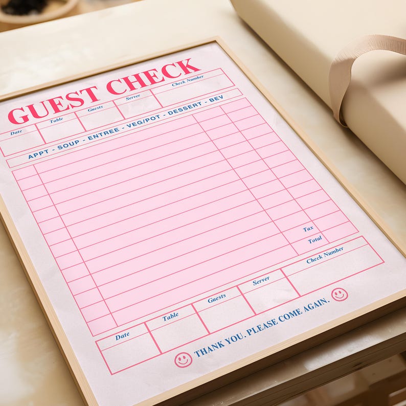 Puede incluir: Un cheque de invitado rosa en un marco de madera. Las palabras "GUEST CHECK" est&aacute;n impresas en rosa en la parte superior. El cheque incluye secciones para la fecha, la mesa, los invitados, el camarero y una lista de alimentos y bebidas. La parte inferior dice "THANK YOU. PLEASE COME AGAIN."