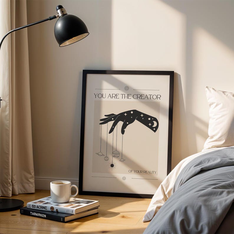 Puede incluir: Una ilustraci&oacute;n en blanco y negro de una mano sosteniendo cuerdas atadas a planetas. El texto "You are the creator of your reality" est&aacute; debajo de la imagen.