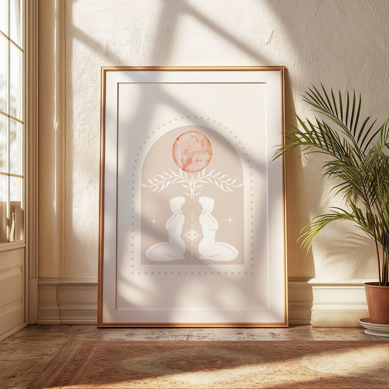 K&ouml;nnte beinhalten: Ein gerahmter Druck mit einem minimalistischen Design, das zwei Figuren zeigt, die sich gegen&uuml;berstehen, mit einem gro&szlig;en, pfirsichfarbenen Kreis dar&uuml;ber. Die Figuren sind in Wei&szlig; umrandet und befinden sich in einem Bogen. Der Hintergrund ist hellbeige.