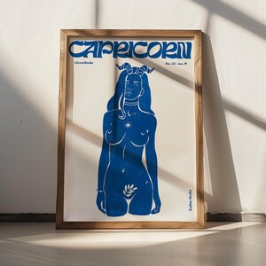 May include: A blue and white poster with the text "Capricorn" in a stylized font. The poster features a blue silhouette of a woman with horns, a star, and a leaf.