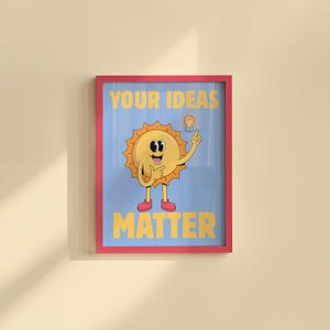 May include: A framed poster with a cartoon sun character on a light blue background. The sun has a smiling face, pointing finger, and a lightbulb above its head. The words "YOUR IDEAS MATTER" are in yellow.
