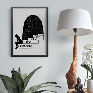 Puede incluir: Ilustraci&oacute;n en blanco y negro de una persona sentada en unos escalones que conducen a un arco estrellado. El texto "You are the universe" est&aacute; escrito debajo de los escalones.