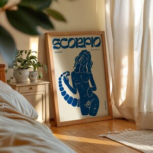 Pode incluir: Um p&ocirc;ster ilustrado azul e branco com a palavra "Scorpio" em uma fonte estilizada. O p&ocirc;ster apresenta uma silhueta azul de uma mulher com uma cauda de escorpi&atilde;o.