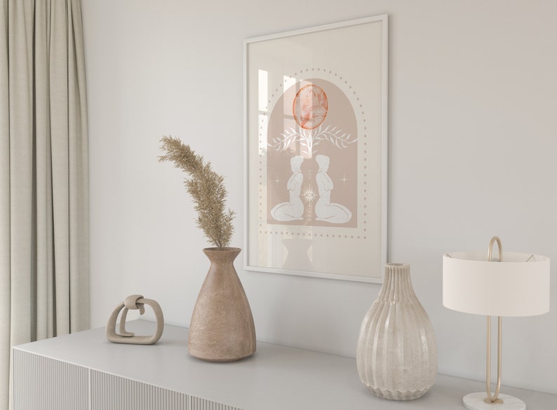 K&ouml;nnte beinhalten: Ein gerahmter Druck mit einem minimalistischen Design, das zwei Figuren in kniender Haltung zeigt, die sich gegen&uuml;berstehen. Die Figuren sind wei&szlig; vor einem pfirsichfarbenen Hintergrund mit einem gro&szlig;en orangen Kreis und floralen Akzenten. Der Druck ist in Wei&szlig; gerahmt.