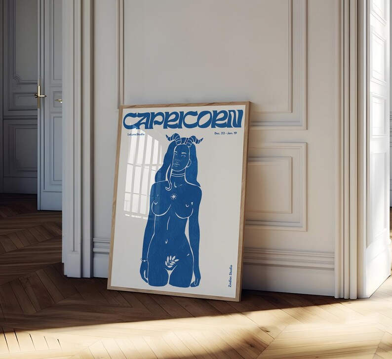 May include: Blue and white poster with a stylized illustration of a woman with horns and a star on her chest. The text "Capricorn Dec. 22 - Jan. 19" is at the top of the poster.
