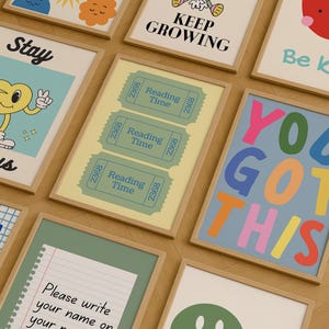 May include: A collection of framed art prints with various designs and text. One print says "KEEP GROWING" with a flower illustration. Another says "YOU GOT THIS" in colorful letters. Other prints feature a smiley face, hearts, and the text "Reading Time".