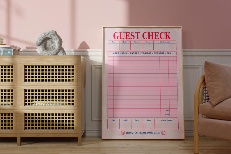 Puede incluir: Un letrero "GUEST CHECK" rosa y blanco enmarcado. El letrero tiene un dise&ntilde;o de cuadr&iacute;cula con espacios para los detalles del pedido. El texto "THANK YOU. PLEASE COME AGAIN" est&aacute; en la parte inferior. El letrero se muestra en una habitaci&oacute;n con un mueble de madera y una pared rosa.