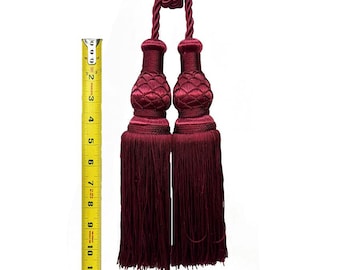 May include: A pair of burgundy tassel tiebacks with a rope detail. The tassels are approximately 12 inches long.