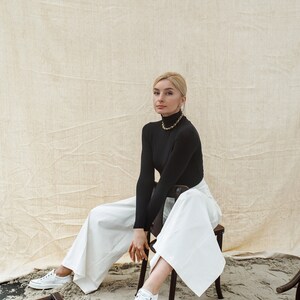 Women dress pants from white cotton fabric with high waist, back vents and pockets