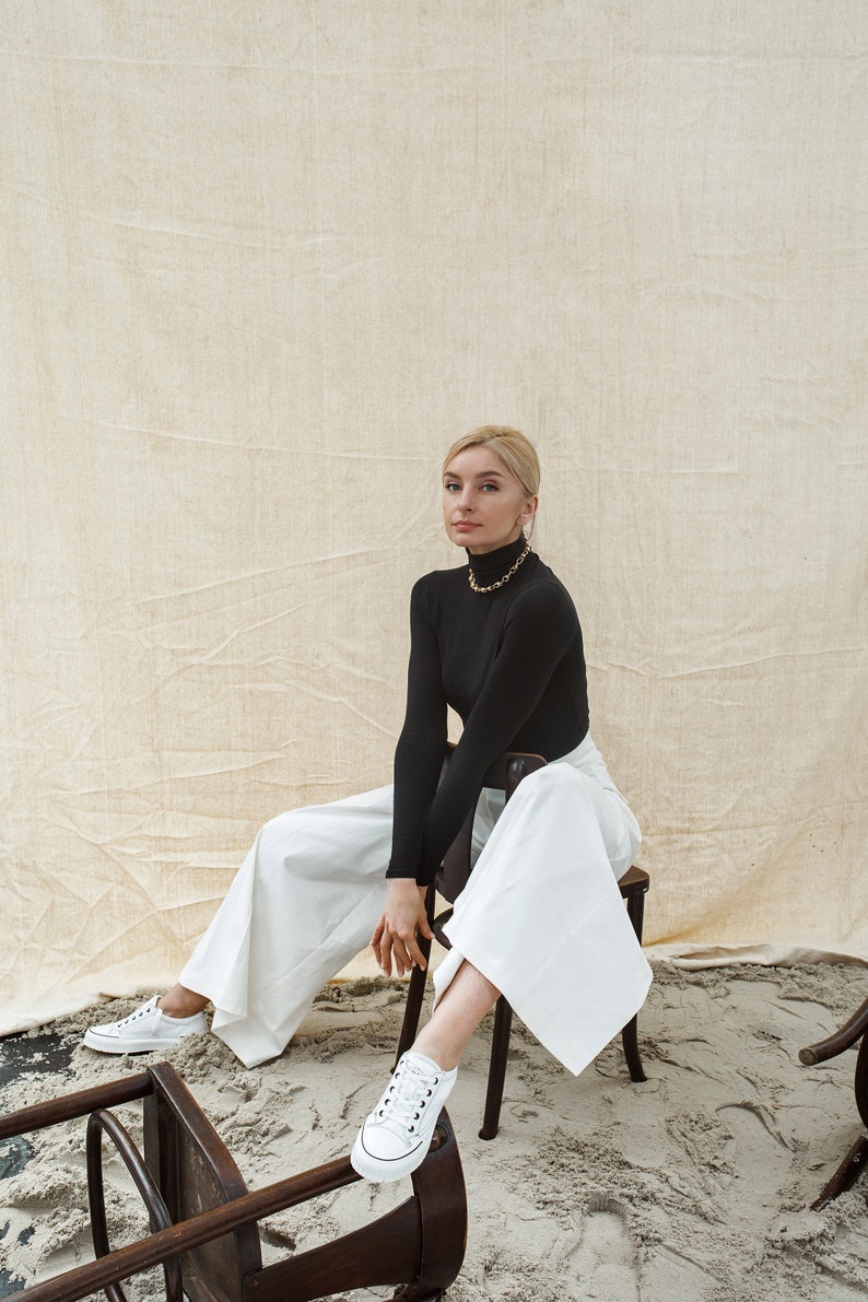Women dress pants from white cotton fabric with high waist, back vents and pockets