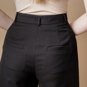 May include: Black high-waisted pants with a straight leg and two back pockets.