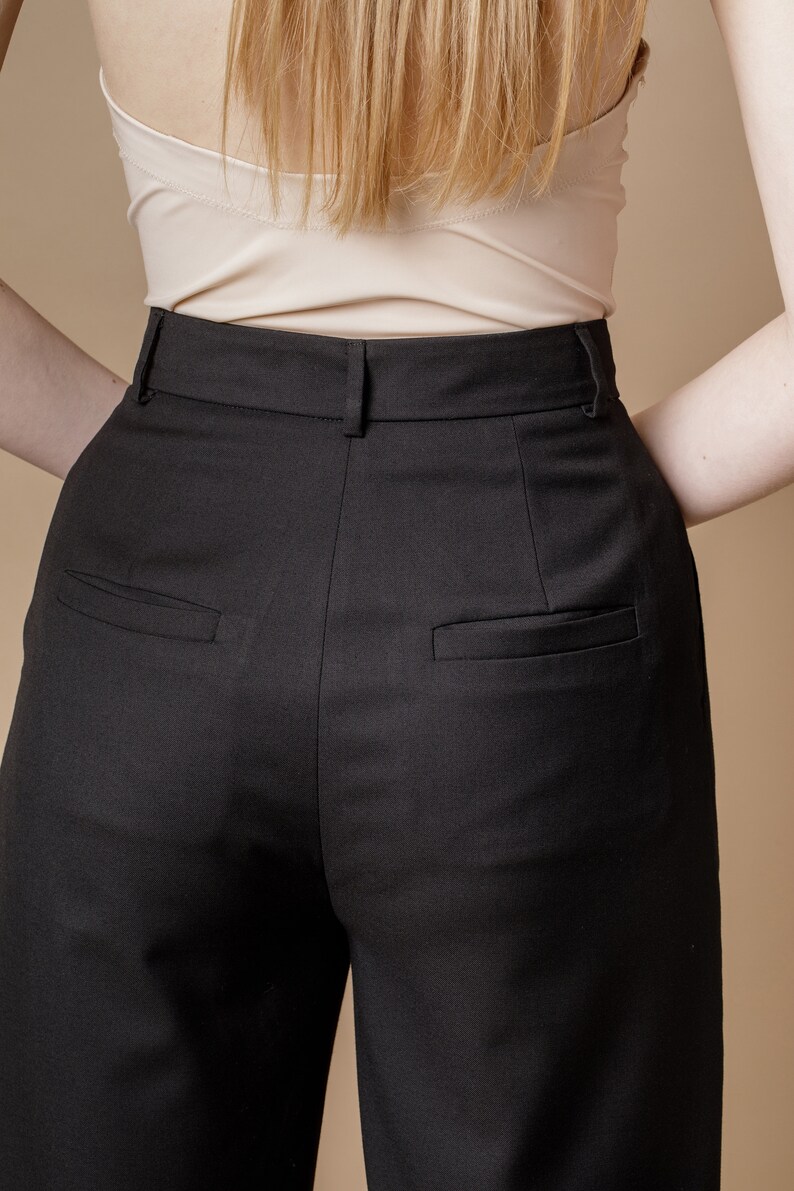 May include: Black high-waisted pants with a straight leg and two back pockets.