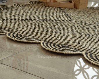 May include: A natural fiber rug with a scalloped edge. The rug features a striped pattern in black and beige, with a decorative border of concentric circles. The rug is placed on a tiled floor.