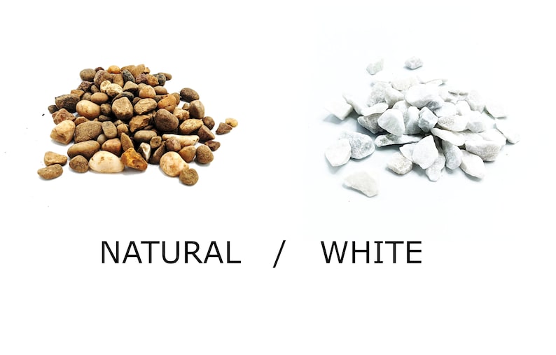 May include: Two piles of decorative stones, one pile of natural brown and white stones, and one pile of white stones. The text "NATURAL / WHITE" is below the piles of stones.