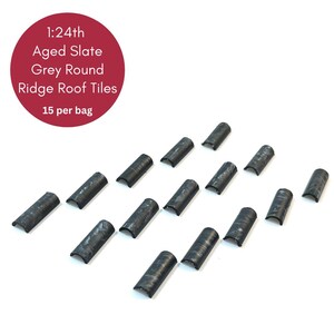 May include: Aged slate grey round ridge roof tiles, 1:24th scale. The image shows 15 dark grey, curved roof tiles. A red circle in the upper left corner displays the product details. The tiles are arranged on a white background.