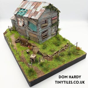 May include: A white ceramic mug with a black handle and the text "But First, Coffee" in a handwritten style. The mug is on a white surface. The mug is approximately 10 cm tall.