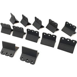 May include: A set of black metal brackets, each featuring a right-angle bend and multiple holes along the top edge. The brackets are displayed on a white background, highlighting their design and construction.