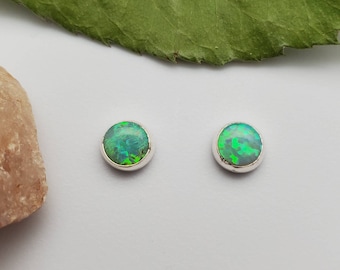 Puede incluir: Un par de pendientes de botón de plata con piedras preciosas de ópalo verde.