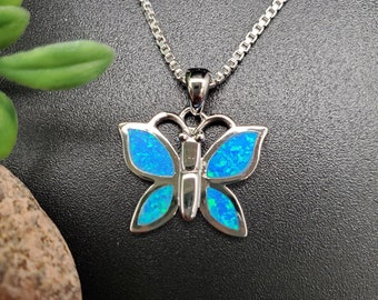 May include: A silver chain necklace with a blue opal butterfly pendant.