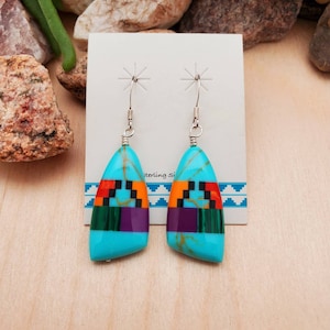 May include: A pair of turquoise, purple, green, orange, and black inlay dangle earrings with sterling silver hooks.