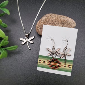 May include: A set of sterling silver dragonfly earrings and necklace with pink opal accents. The earrings are dangle style and the necklace has a chain style.