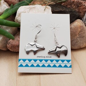 May include: Sterling silver bear dangle earrings on a white card with the text "Sterling Silver".