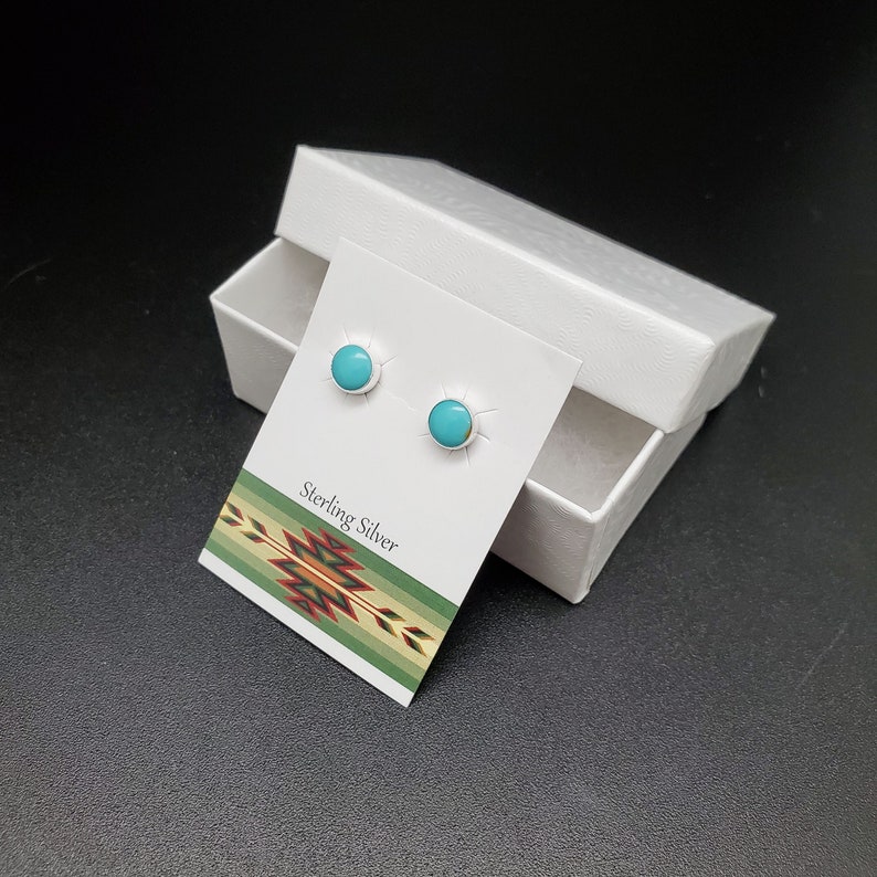 May include: A pair of turquoise and sterling silver stud earrings in a white box. The box has a card inside that says "Sterling Silver".