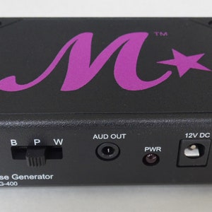 May include: Black pink noise generator with a purple M star logo, labeled "Pink Noise Generator Model PNG-400". It has a power switch, an audio output jack, and a 12V DC power input.