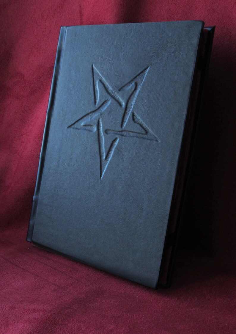 May include: A black leather-bound journal with a five-pointed star embossed on the front cover.