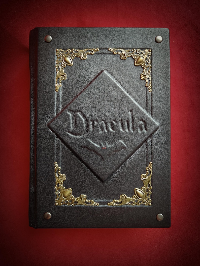 May include: A black leather-bound book with gold accents and the title "Dracula" embossed on the front cover.