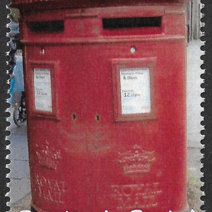 以下が含まれることがあります： ロイヤル紋章と「Positively Postal」という文字が書かれた赤いイギリスのヴィンテージ郵便ポスト。郵便ポストには郵便物を投函するためのスロットが2つと、回収時間の書かれた看板があります。