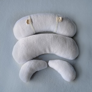 May include: Set of four white, plush, crescent-shaped pillows for newborn photography props. The pillows are made of soft, fluffy material and are perfect for creating a cozy and comfortable setting for baby photos.