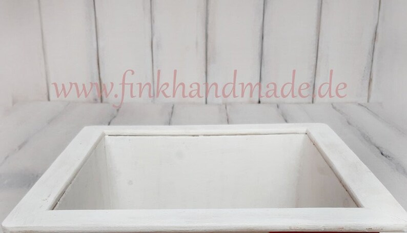 Puede incluir: Caja de madera blanca con una abertura cuadrada. La caja est&aacute; sobre una superficie de madera blanca. El texto "www.finkhandmade.de" es visible en la superficie.