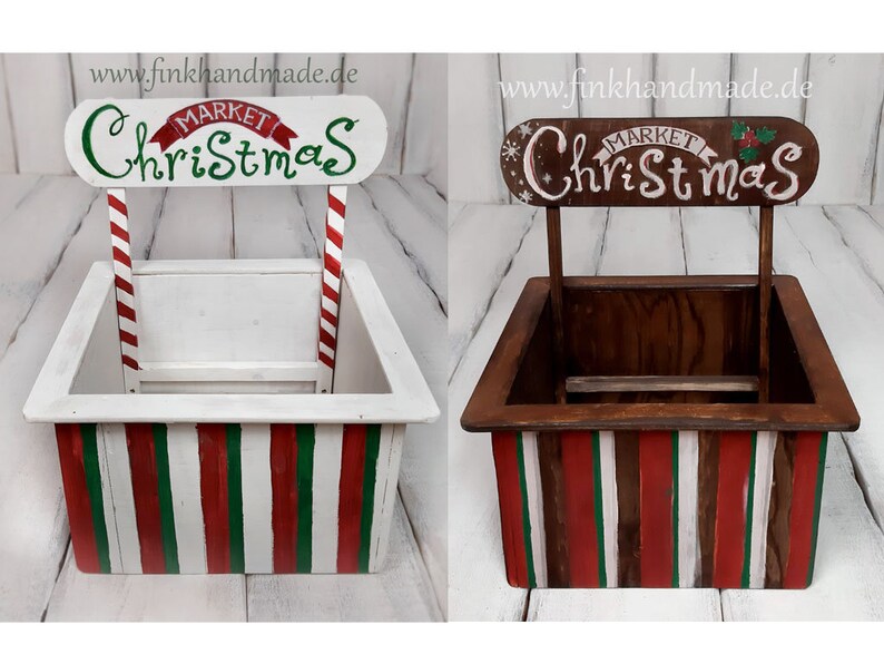 Puede incluir: Dos puestos de mercado navide&ntilde;o de madera con los lados a rayas rojas y verdes. Los puestos est&aacute;n pintados de blanco y tienen un letrero que dice "Mercado de Navidad".