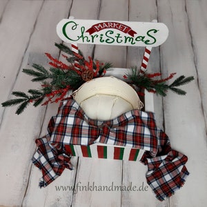 Puede incluir: Un puesto de mercado navide&ntilde;o de madera blanca con un techo a rayas rojas y verdes. El puesto est&aacute; decorado con una tela a cuadros y un cuenco de metal blanco. El letrero en el puesto dice "Mercado Navide&ntilde;o".