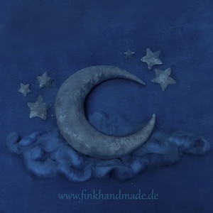 以下が含まれることがあります： 濃い青色の背景に、フェルト製の三日月と星5つが配置されています。三日月は、同じくフェルト製の雲のような形の上に置かれています。画像の下部には「www.finkhandmade.de」というテキストが表示されています。