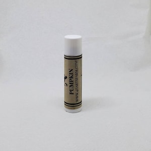 May include: A white tube of lip balm with a brown label that says "PUMPKIN" and "www.411artsfarm.com".