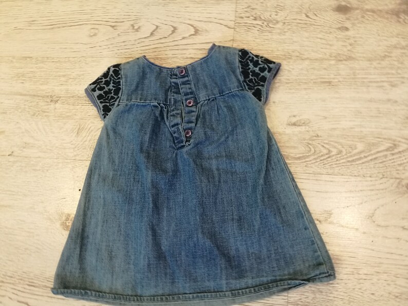 at the front with wrinkles,healthy with botton closure on the back embroidery with small sleeves about 1 year Denim dress little girl